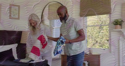 Packing and Organizing Luggage by Mature Couple in Bright Minimalist Bedroom for Travel