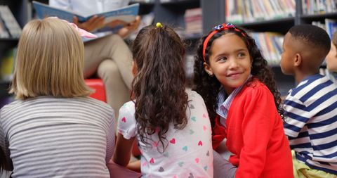 Smiling Schoolgirl Engaged in Classroom Library Storytime Activity - Download Free Stock Images Pikwizard.com
