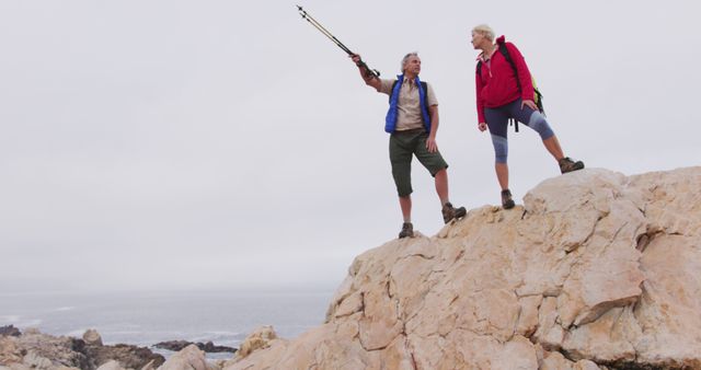 Senior Couple Hiking on Rocky Cliff with Ocean View - Download Free Stock Images Pikwizard.com