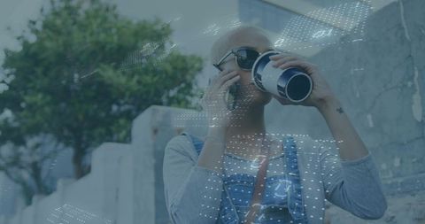 Urban woman sipping coffee talking on phone wearing sunglasses denim overalls dotted overlay