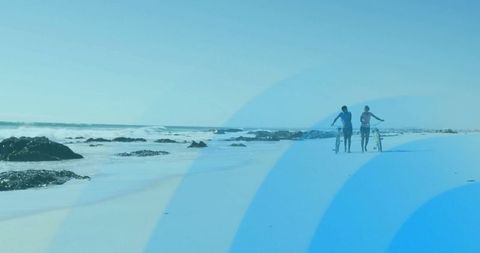 Couple enjoying leisurely beach walk with bicycles