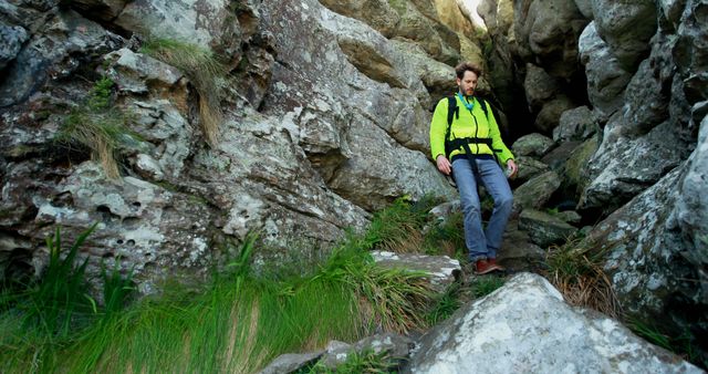 Hiker in green jacket descending rocky mountain trail - Download Free Stock Images Pikwizard.com