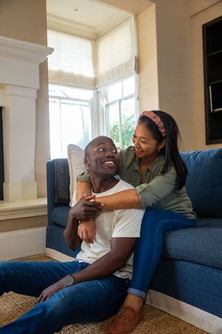 Couple embracing on sofa in cozy living room environment