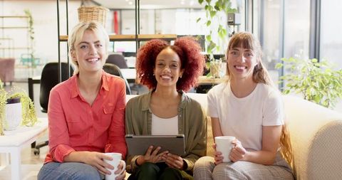 Friendly Female Team Collaborating in Modern Office Lounge