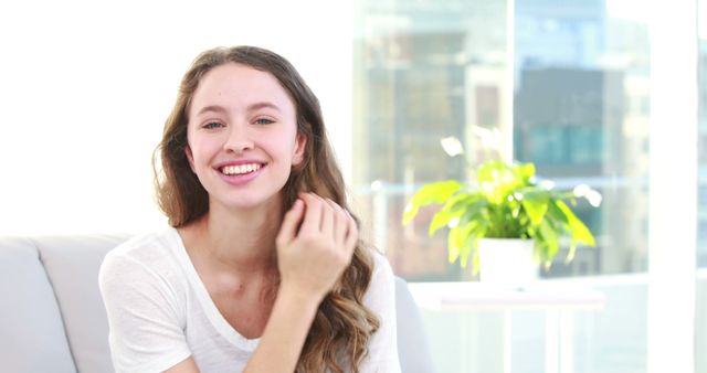 Smiling Young Woman with Long Hair Sitting in Bright Room - Download Free Stock Images Pikwizard.com