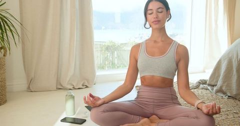 Serene Woman Meditating at Home with Peaceful Expression