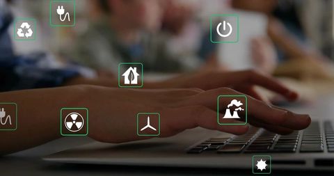 Hands typing on laptop with floating energy icons representing sustainable technology