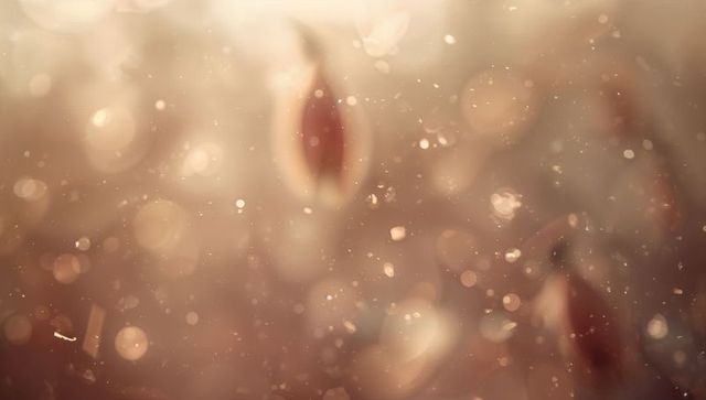 Warm golden bokeh with drifting particles and soft leaf-shaped orbs, dreamy macro background