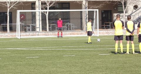 Soccer Team Prepping for Penalty Training on Field