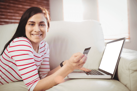Smiling Woman Shopping Online with Laptop and Credit Card