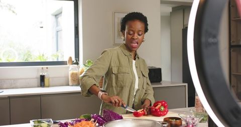 Live Cooking Content: African American Woman Preparing Colorful Veggie Meal on Kitchen Island