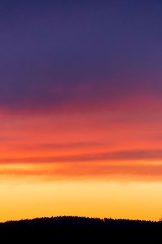 Vivid Gradient Sunset Over Silhouetted Hills with Purple, Pink and Orange Sky