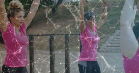 Diverse Women Utilizing Virtual Fitness Interface Outdoors