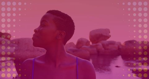 Young Woman Enjoying Serene Coastal Views Amidst Rocks