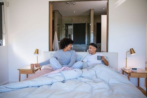 Couple Enjoying Morning Tea in Cozy Bedroom Setting