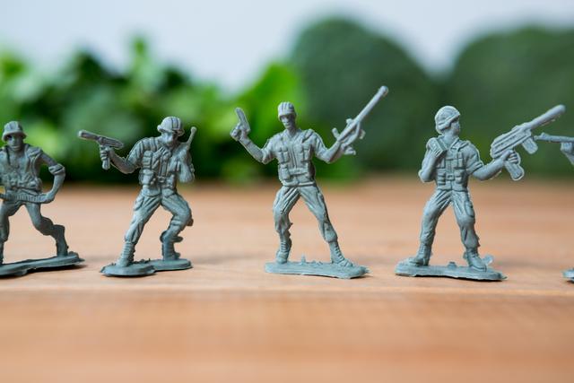 This image depicts a row of miniature army soldiers in battle formation, ideal for use in articles or advertisements related to military strategy games, childhood toys, or hobby collections. It can also be used in educational content about military history or in marketing materials for toy stores.
