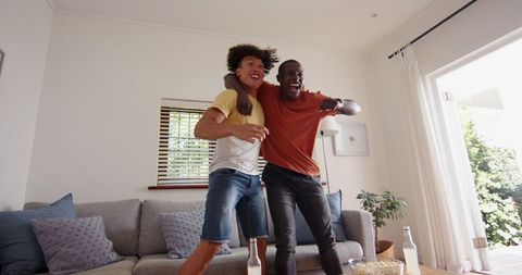 Diverse Friends Celebrating in Living Room with Game Controller