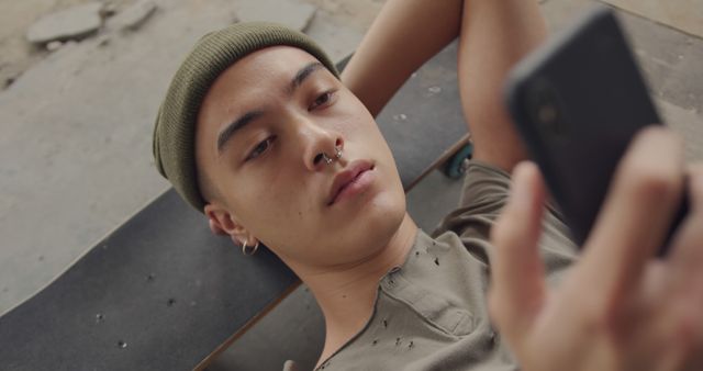 Young Man Lying on Skateboard Using Smartphone Outdoors - Download Free Stock Images Pikwizard.com