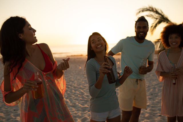 Group of friends enjoying drinks on a beach at sunset. Perfect for promoting vacation destinations, summer activities, social events, and lifestyle products. Ideal for use in travel brochures, social media campaigns, and advertisements for beach resorts or beverage brands.