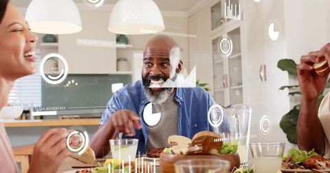 Multigenerational family gathering around kitchen table sharing meal, laughing, connecting