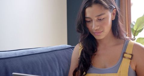 Teenage girl using laptop in cozy home environment