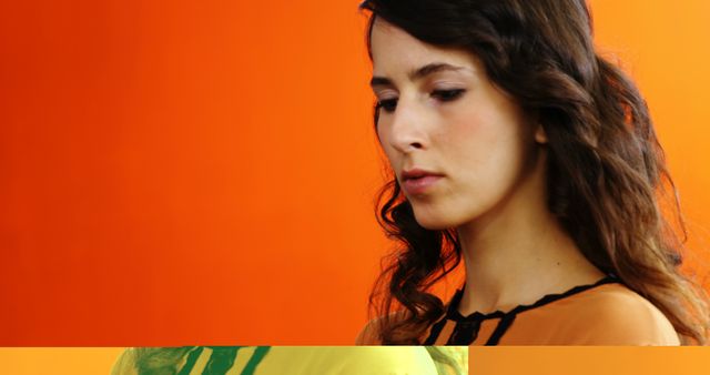 Thoughtful Young Woman Against Vibrant Orange Background - Download Free Stock Images Pikwizard.com