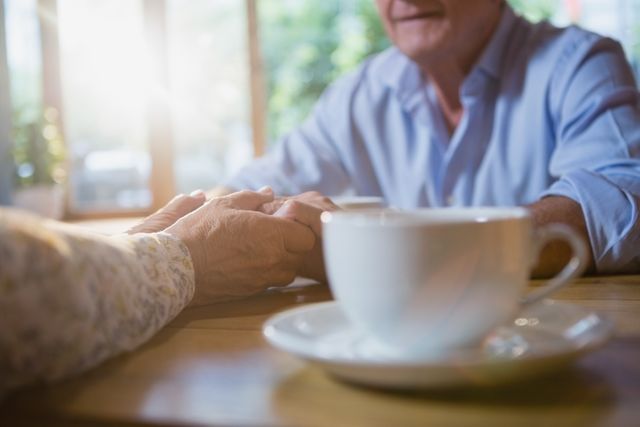 Senior couple holding hands over coffee - Download Free Stock Photos Pikwizard.com