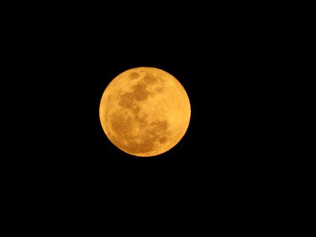 Glow of a full moon captured against a stark black sky. Ideal for articles on astronomy, seasons, or natural phenomena. Engages those interested in celestial bodies, seasonal changes, or peaceful night scenes.