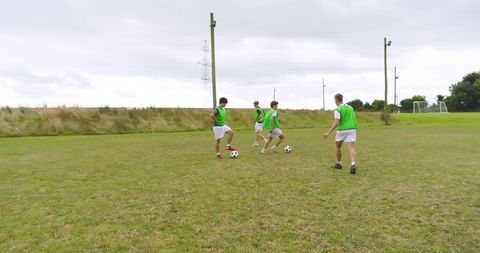 Teenage Boys Practicing Soccer Skills on Outdoor Field
