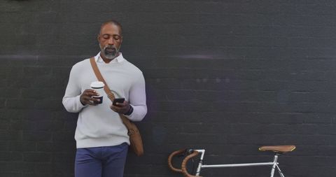 African american man commuting with smartphone and coffee