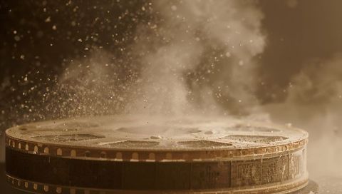 Resting vintage film reel gathering dust and smoke in sepia cinematic nostalgia