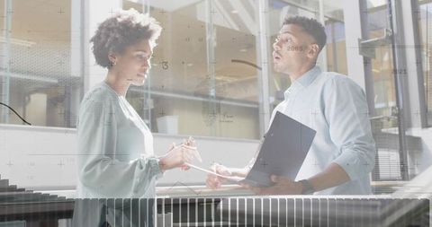 Colleagues Collaborating in Modern Office Atrium with Data Overlay