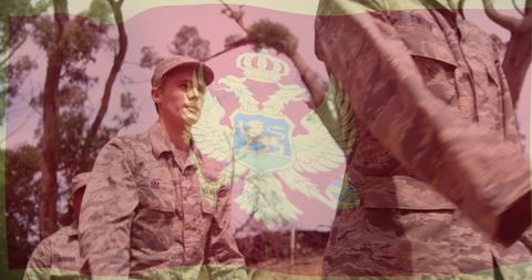 Soldier in camouflage receiving salute with heraldic crest overlay, patriotic discipline