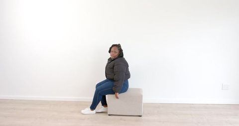 Woman Relaxing on Ottoman in Minimalist Bright Room - Download Free Stock Images Pikwizard.com