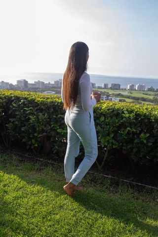 Serene Woman Gazing at Urban Landscape with Mug