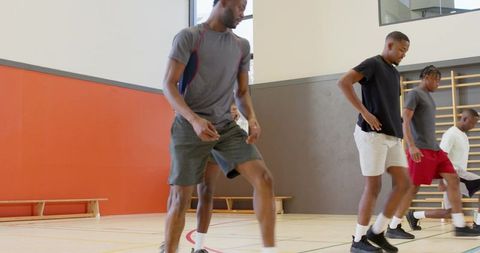 African american men performing basketball warmup drills in indoor gym team training