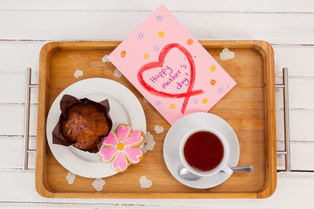 Happy mothers day greeting card with tea and snacks on wooden tray