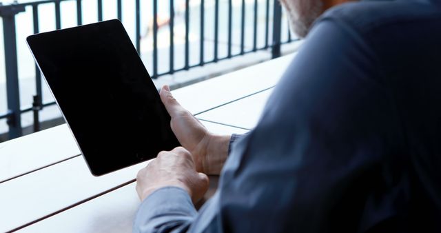 Businessman Using Tablet on Outdoor Coffee Table in Urban Setting - Download Free Stock Images Pikwizard.com