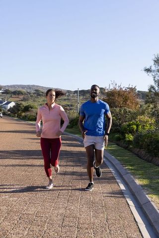 Diverse Friends Jogging Along Suburban Pathway