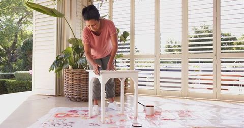 Woman focusing on diy table painting home improvement project
