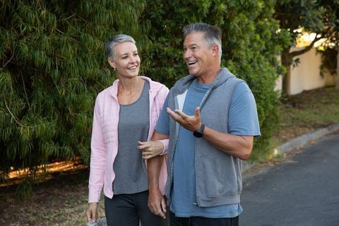 Active Senior Couple Enjoying Walk in Green Suburban Street