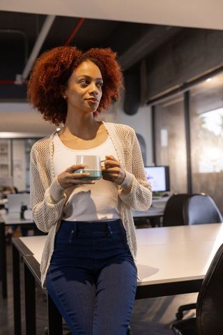 Professional Woman Relaxing with Coffee in Modern Office