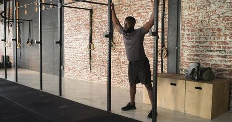 Athletic Man Exercising on Pull-Up Bar in Modern Gym Environment