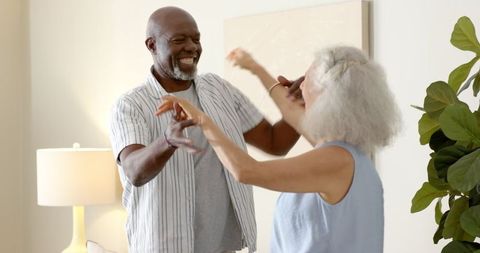 Joyful Senior Couple Dancing in Minimalist Living Room