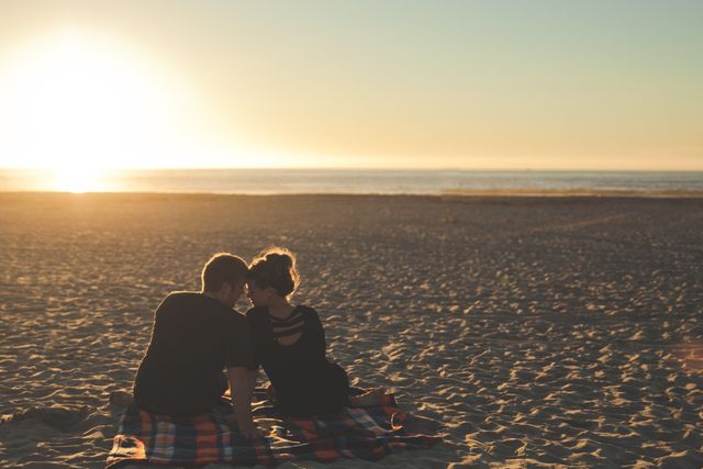 Couple Sitting on Beach at Sunset Enjoying Romantic Moment - Download Free Stock Photos Pikwizard.com