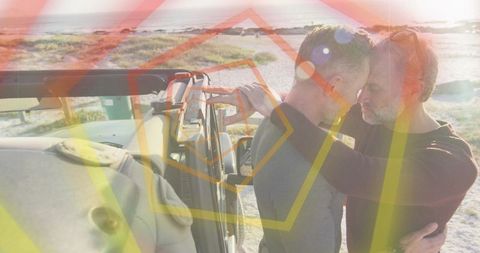Middle-aged gay couple embracing by suv on coastal dunes with sunset lens flare