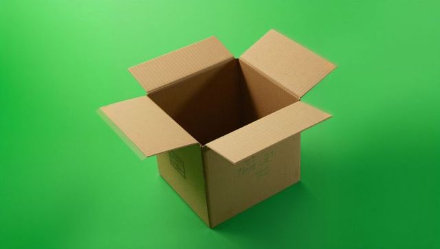 Empty cardboard box on green background for shipping and packaging