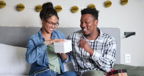 Happy Couple Celebrating Anniversary By Unwrapping Gifts