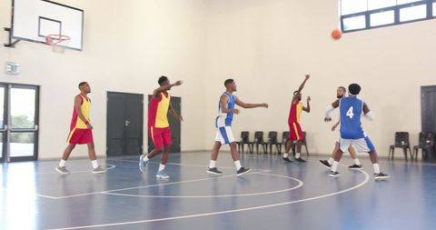 Energetic basketball game with diverse athletes on indoor court