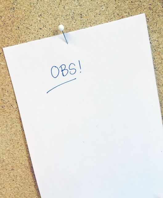 Pinned white paper notice on a corkboard. Ideal for illustrating concepts related to office communication, organizing information, announcements, reminders, and workspace layout. Useful for educational, professional, or home office settings.